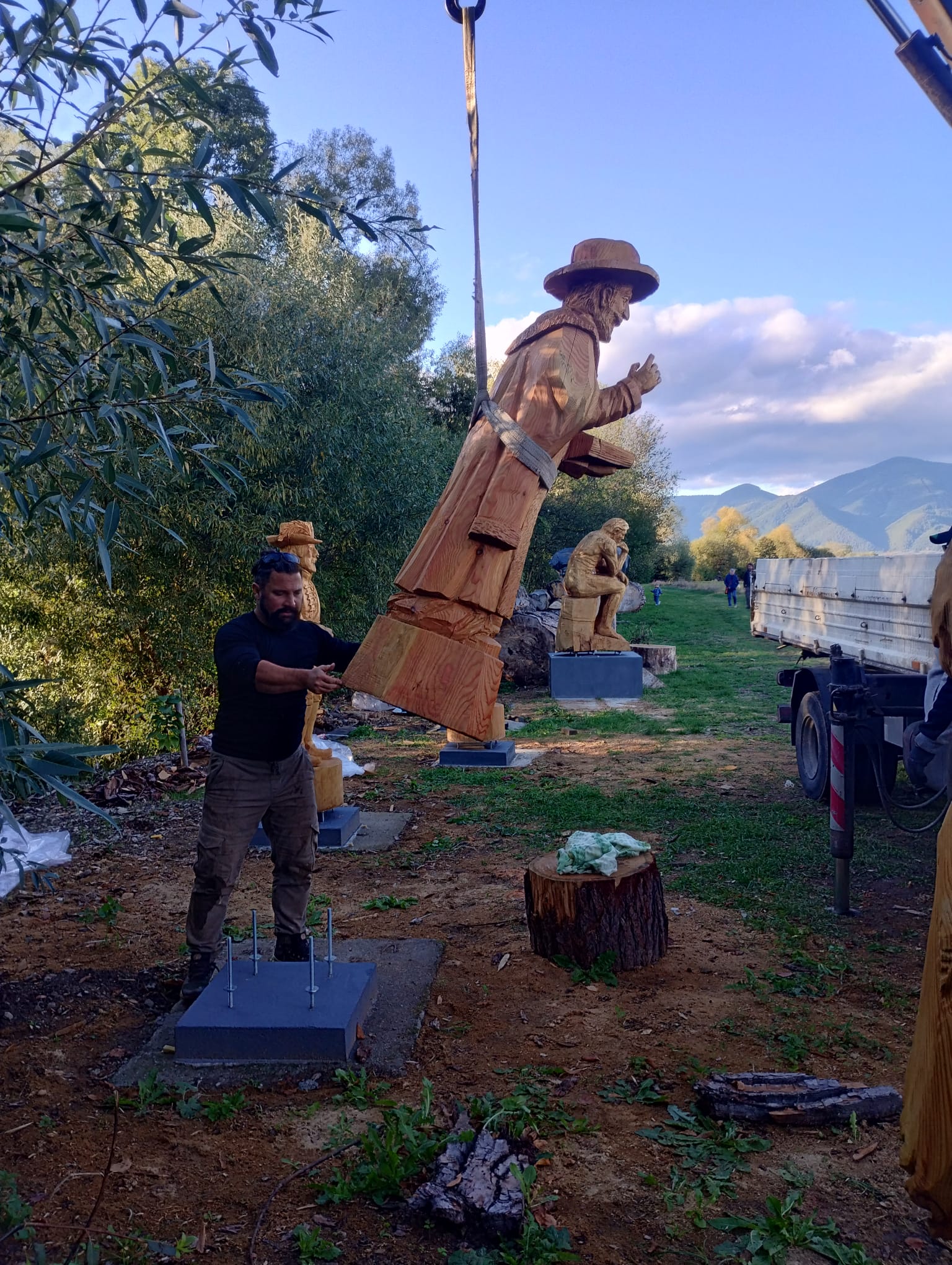Osádzanie hotovej drevenej sochy pomocou hydraulickej ruky v galérii pri Jordáne